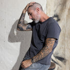 Premium Fitted Heritage Tee in Washed Black, seated on model