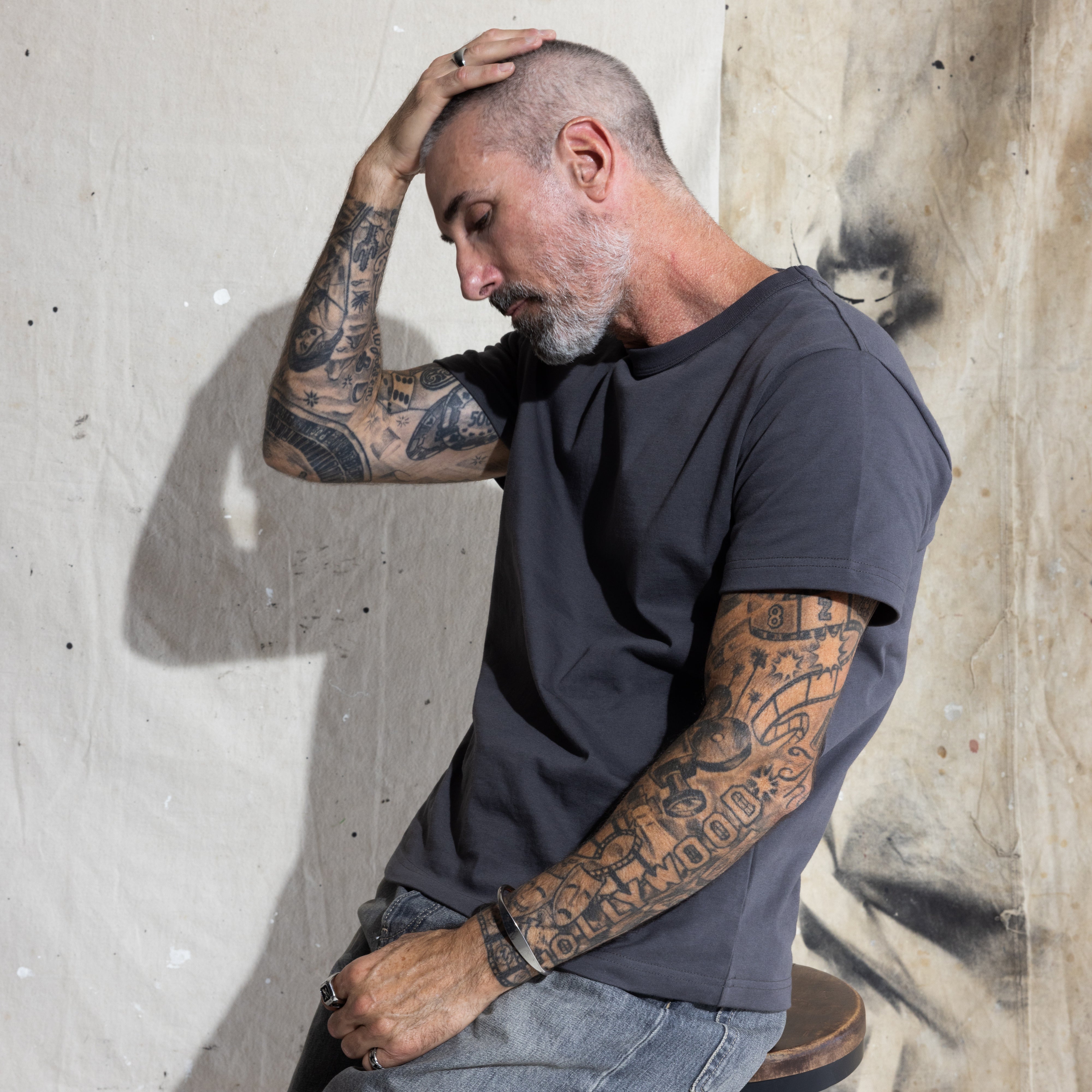Premium Fitted Heritage Tee in Washed Black, seated on model